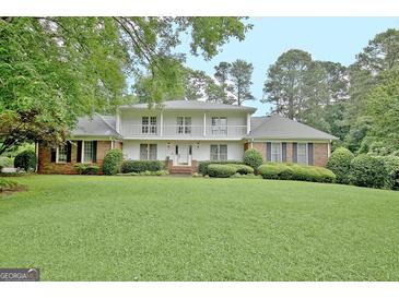 Charming two-story home with a well-manicured lawn, brick accents and a second story balcony at 550 Hawthorne Dr, Fayetteville, GA 30214