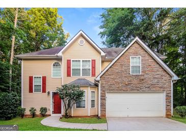 Charming two-story home with stone accents, red shutters, and a well-manicured lawn at 8330 N Sterling Lakes Dr, Covington, GA 30014