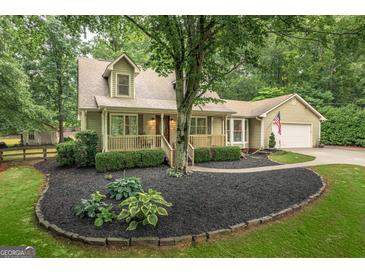 Charming two-story home featuring a cozy front porch, manicured landscaping, and an attached two car garage at 4080 Derby Dr, Cumming, GA 30040