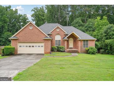Charming brick home with well-manicured lawn and attached two-car garage at 1214 Lambeth Se Way, Conyers, GA 30013