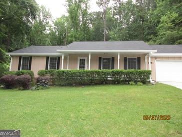 Charming single-story home with manicured lawn, trimmed bushes, and a welcoming front porch at 5848 Navarre Ct, Stone Mountain, GA 30087