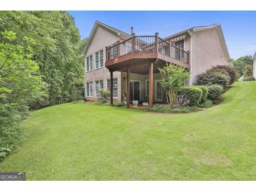 Expansive backyard featuring a spacious deck, lush lawn, and mature trees, perfect for outdoor entertaining at 133 Sea Island Dr, Peachtree City, GA 30269