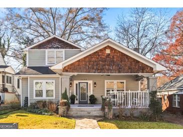 Charming two-story home featuring a quaint front porch, unique cedar shake details, and a landscaped front yard at 1450 Elizabeth Ln, East Point, GA 30344