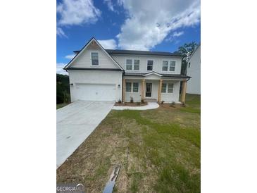 Charming white two-story home with a well-manicured lawn and a two-car garage at 129 Silvercrest Dr # 57, Acworth, GA 30101