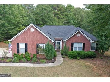 Charming brick home featuring a well-manicured lawn, lush landscaping, and a welcoming front entrance at 1129 River Green Ct, Mcdonough, GA 30252