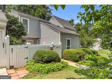 Charming home exterior with a white picket fence and well-maintained landscaping creating a welcoming curb appeal at 2694 Greentree Se Dr, Marietta, GA 30067