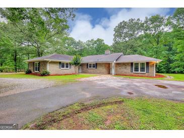 Charming brick ranch home featuring a circular driveway and beautifully landscaped front yard at 100 Willow Wood Road, Social Circle, GA 30025