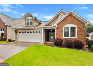 Charming home featuring a well-maintained lawn and two-car garage at 130 Augusta Dr, Peachtree City, GA 30269