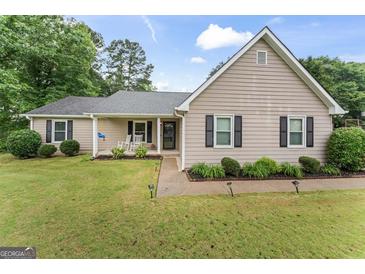 Charming home with well-manicured lawn, rocking chairs on the porch, and swing at 200 Pine Tree Ln, Mcdonough, GA 30252