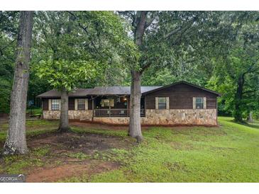Charming single-story home with stone accents and a welcoming front porch, nestled among mature trees in a quiet setting at 69 Trace Ct, Stockbridge, GA 30281