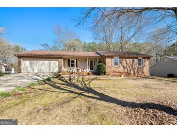 Charming brick home featuring an attached two-car garage and a well-maintained front yard at 55 Helen Ln, Stockbridge, GA 30281