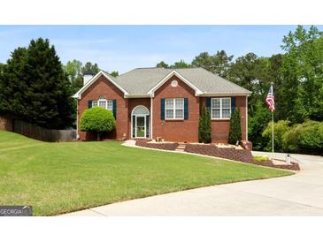 Charming brick home featuring a lush lawn, manicured landscaping, and inviting curb appeal at 1112 Haver Ct, Mcdonough, GA 30252