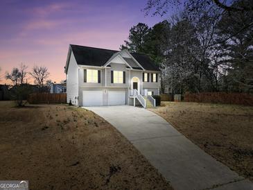 Two-story home featuring a well-manicured lawn and a two-car garage at dusk at 8870 Dornoch Cir, Winston, GA 30187