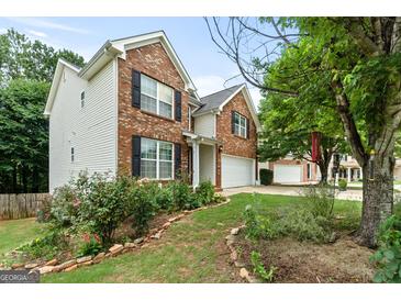 Charming two-story home with a brick facade, vinyl siding, landscaped yard, and attached two-car garage at 2009 Parador Aly, Mcdonough, GA 30253