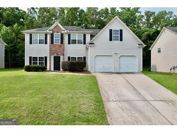Charming two-story home with a well-manicured lawn, attached two-car garage, and traditional design elements at 3205 Anneewakee Falls Pkwy, Douglasville, GA 30135