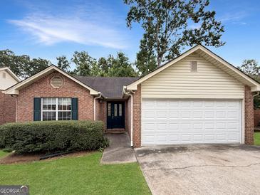 Charming one-story brick home with a well-maintained lawn and attached two-car garage at 106 Oakwood Cir, Stockbridge, GA 30281