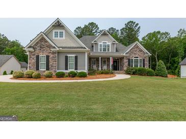 Charming home featuring stone accents, manicured landscaping, and a welcoming walkway at 319 Beaconsfield Dr, Sharpsburg, GA 30277