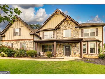 Beautiful two-story home featuring a stone facade, inviting front porch, and well-manicured lawn at 150 Bellemeade Ct, Fayetteville, GA 30215