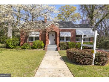 Charming brick home with a well-manicured lawn and beautiful flowering tree in the front yard at 109 Stockbridge Rd, Jonesboro, GA 30236