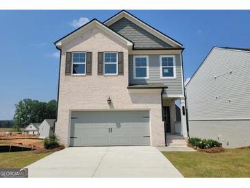 New two-story home with a two car garage, brick, siding, and professionally landscaped front yard at 42 Avian Way # 128B, Auburn, GA 30011