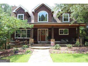 Charming brown home with landscaped front yard, inviting covered porch, and stone accents at 99 Landers Ne Rd, Rydal, GA 30171
