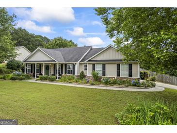 Charming single story home with manicured lawn, mature trees, and colorful flowerbeds adding curb appeal at 301 Bradford Ct, Auburn, GA 30011