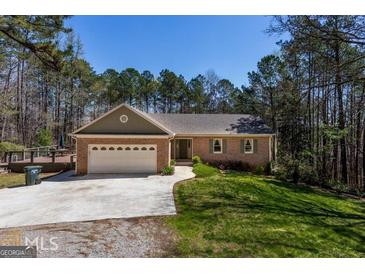 Charming brick home with an attached two-car garage and a spacious front yard in a wooded, tranquil neighborhood at 6340 Koweta Rd, Fairburn, GA 30213