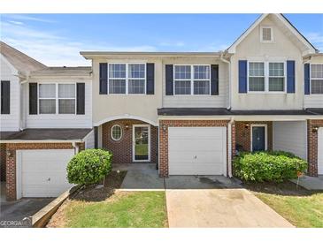Charming townhome featuring a brick facade, garage, and manicured landscaping at 695 Georgetown Ct, Jonesboro, GA 30236