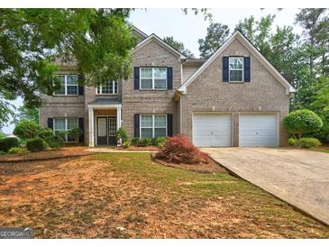 Traditional brick home with an attached two-car garage and well-maintained landscaping at 1132 Hargrove Ct, Locust Grove, GA 30248