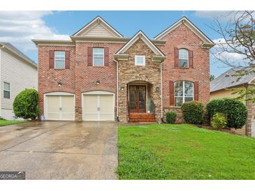 Beautiful two-story brick home featuring a manicured lawn and two-car garage at 1476 Rolling View Way, Dacula, GA 30019