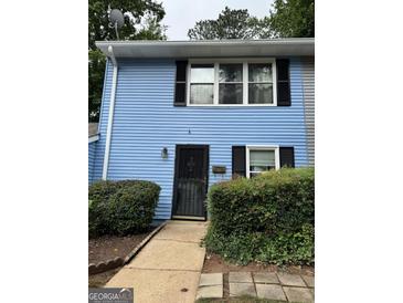 Charming blue townhome featuring black shutters, a black front door, and well-maintained landscaping at 375 Leisure Sw Ct, Marietta, GA 30064