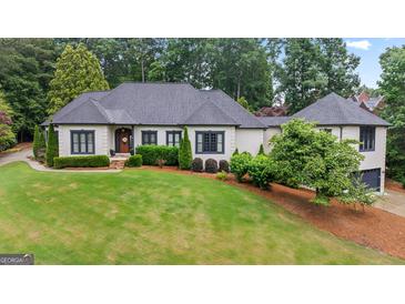 Stately home boasts a manicured lawn, mature trees, and sophisticated architectural details at 4030 River Ridge Chase Se, Marietta, GA 30067