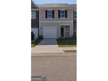 Charming townhouse with a one-car garage, black shutters, and a well-manicured lawn at 11992 Fuller St, Hampton, GA 30228