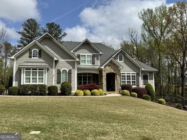 Beautiful two-story home featuring stone accents, manicured lawn, and lush landscaping at 265 Beverly Farms Dr, Sharpsburg, GA 30277