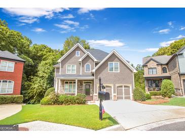 Charming two-story home with a well-manicured lawn and attached two-car garage at 931 Hidden Falls Se Ln, Smyrna, GA 30082