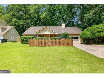 Charming one-story home featuring a wooden fence, attached garage, and lush green lawn at 110 Long Leaf, Peachtree City, GA 30269