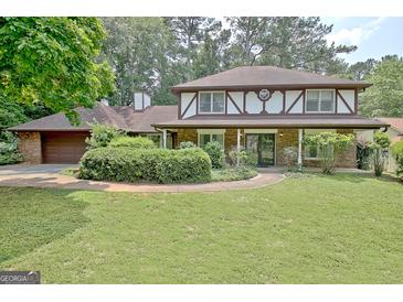 Charming home featuring Tudor-style architecture and a well-manicured lawn at 212 Garret Rdg, Peachtree City, GA 30269