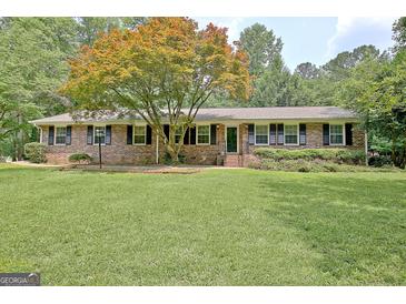 Charming brick home with a lush green lawn and beautiful shade tree at 501 Bridlepath Ln, Peachtree City, GA 30269