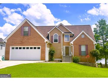 Charming two-story home featuring a brick and siding exterior, manicured lawn and two-car garage at 105 Providence Ct, Carrollton, GA 30116