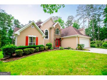 Inviting home with a manicured lawn, red shutters, and a stone accented entrance at 7392 N Mitchell Ct, Villa Rica, GA 30180