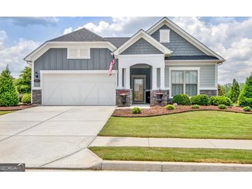 Charming gray two-story home with landscaped yard and covered entryway and well manicured lawn at 411 Southbridge Pass, Peachtree City, GA 30269