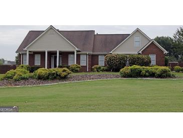 Charming brick home featuring a well-manicured lawn and a welcoming front porch with classic white columns at 1204 Bent Creek Dr, Mcdonough, GA 30252