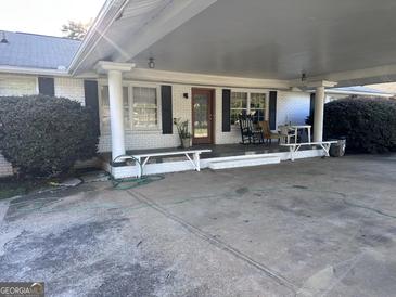Charming brick home featuring an attached carport with a covered front porch and ample seating at 4160 Ewing Rd, Austell, GA 30106
