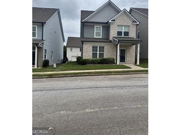 Charming two-story home with light brick and manicured lawn; perfect for curb appeal at 1317 Rosemary Ln # 65, East Point, GA 30344