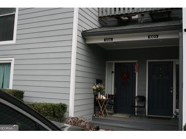 Charming townhome entrance featuring a cozy porch with seating and a decorative front door at 1602 Riverbend Club Drive, Atlanta, GA 30339