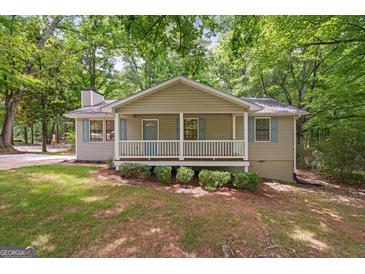 Charming home featuring a cozy front porch with white railings and blue shutters and door at 438 Punkintown Rd, Villa Rica, GA 30180
