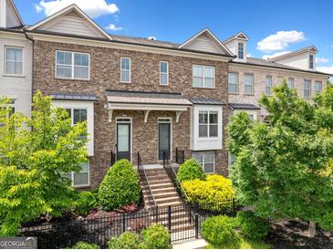 Beautiful brick townhome with well-maintained landscaping, inviting entrance, and neutral colors at 1094 Township Sq, Alpharetta, GA 30022