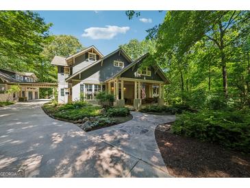 Charming home showcasing meticulous landscaping, stone walkway, and a welcoming front porch with classic American flag at 508 Hastings Dr, Peachtree City, GA 30269