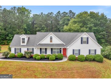 Charming one-story home with a landscaped front yard and a red front door at 506 Brewer Dr, Locust Grove, GA 30248