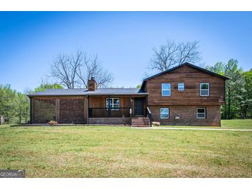 Charming two-story home with a brick and wood facade, front porch, and well-maintained lawn at 1919 101 S Hwy, Temple, GA 30179